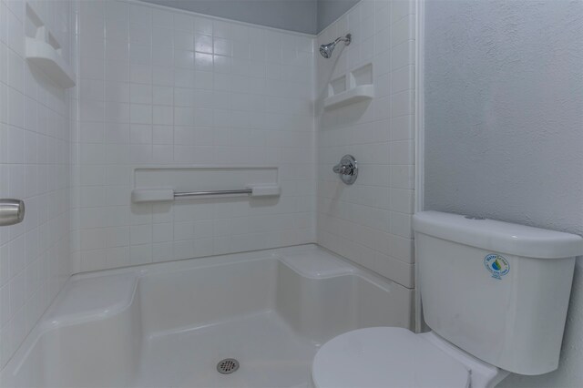 bathroom with toilet and tiled shower / bath combo