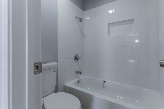 bathroom with toilet and tiled shower / bath combo