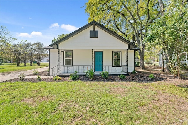 bungalow with covered porch and a front yard