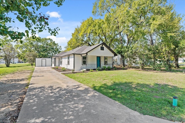 bungalow-style home featuring driveway, covered porch, and a front yard