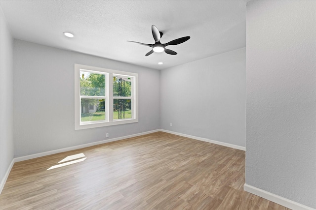 empty room featuring a ceiling fan, a textured ceiling, recessed lighting, light wood-style floors, and baseboards