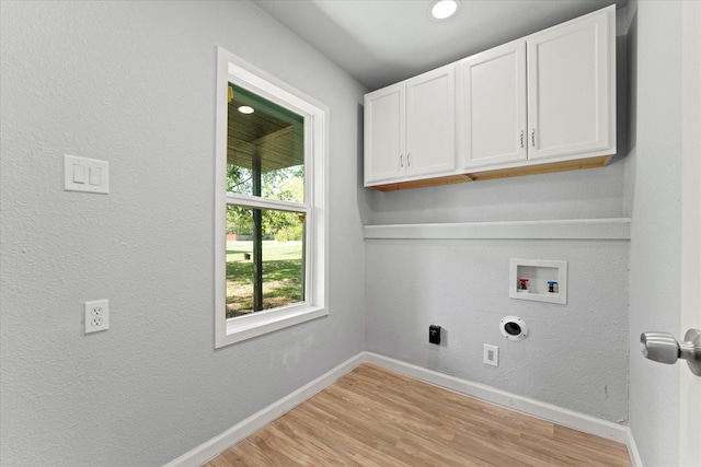 clothes washing area with electric dryer hookup, baseboards, cabinet space, and washer hookup