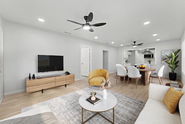 living room with recessed lighting, a ceiling fan, baseboards, and wood finished floors