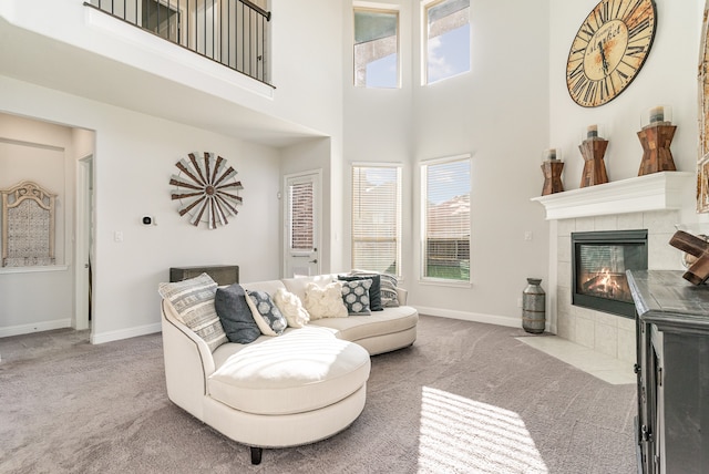 carpeted living room with a high ceiling and a tile fireplace