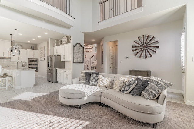 tiled living room with a high ceiling and sink