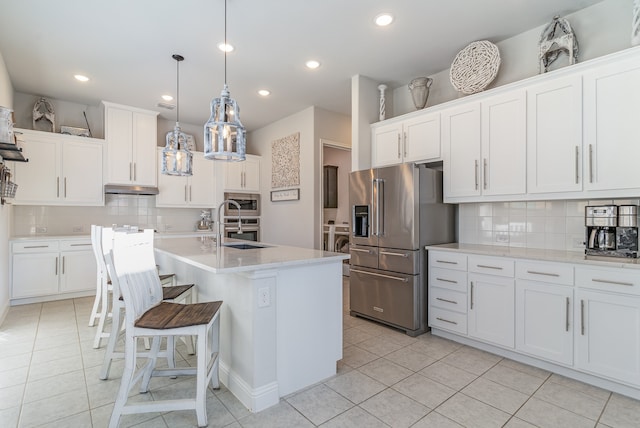 kitchen featuring appliances with stainless steel finishes, tasteful backsplash, decorative light fixtures, and white cabinets