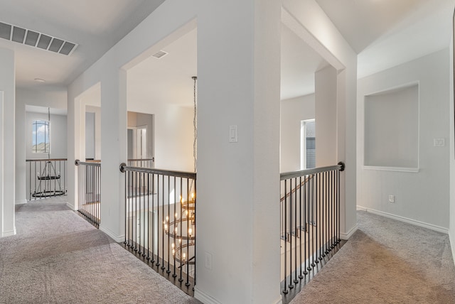 hallway featuring carpet floors and a chandelier