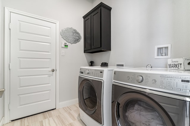 washroom featuring washer and clothes dryer and cabinets