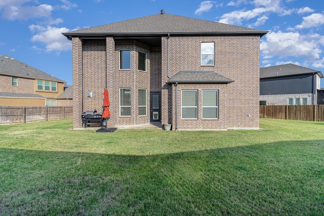 rear view of house featuring a patio and a yard