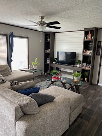 living room with ceiling fan, hardwood / wood-style flooring, and a textured ceiling