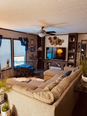 living room with ceiling fan, hardwood / wood-style flooring, and a textured ceiling