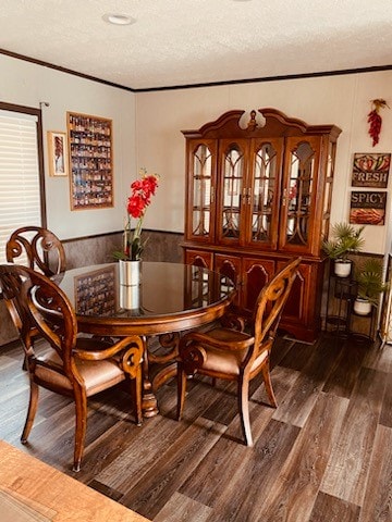 dining room featuring a textured ceiling, dark hardwood / wood-style floors, and crown molding