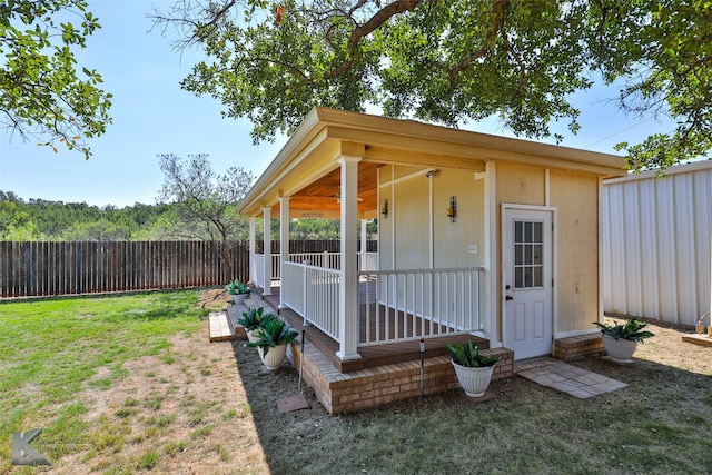 view of outbuilding featuring a lawn and a porch