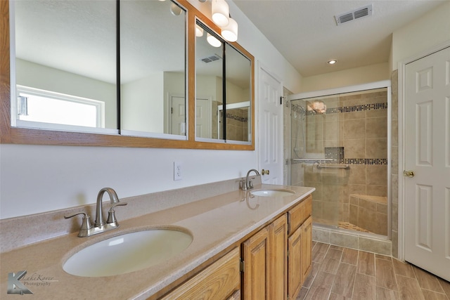 bathroom with vanity and a shower with door