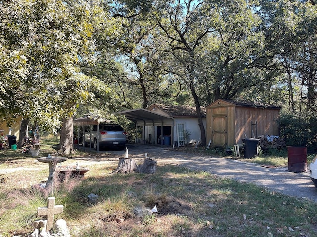 view of front of home with a shed and a carport