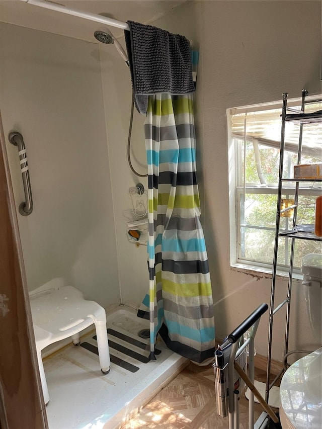 bathroom with a shower with curtain and parquet flooring