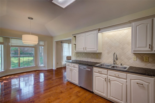 kitchen with dishwasher, dark countertops, light wood-style flooring, vaulted ceiling, and a sink