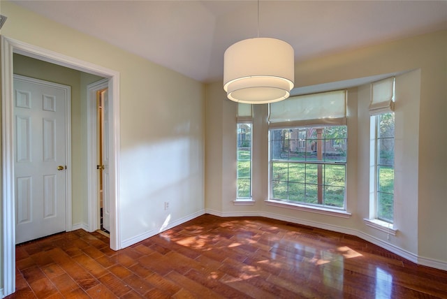 unfurnished dining area with baseboards and dark wood finished floors