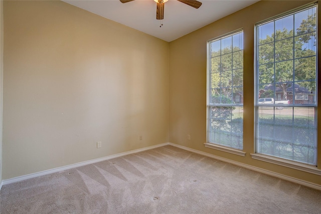 empty room featuring ceiling fan, baseboards, and light colored carpet