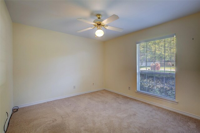 unfurnished room with light colored carpet, ceiling fan, and baseboards