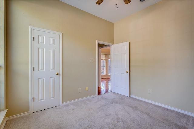 unfurnished bedroom featuring carpet flooring, ceiling fan, visible vents, and baseboards