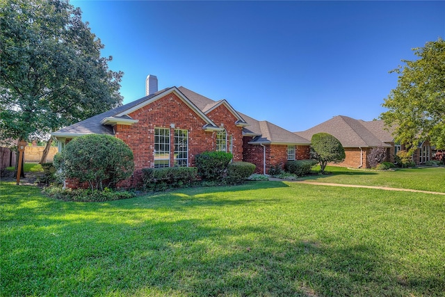 view of front of property with brick siding, a chimney, and a front lawn