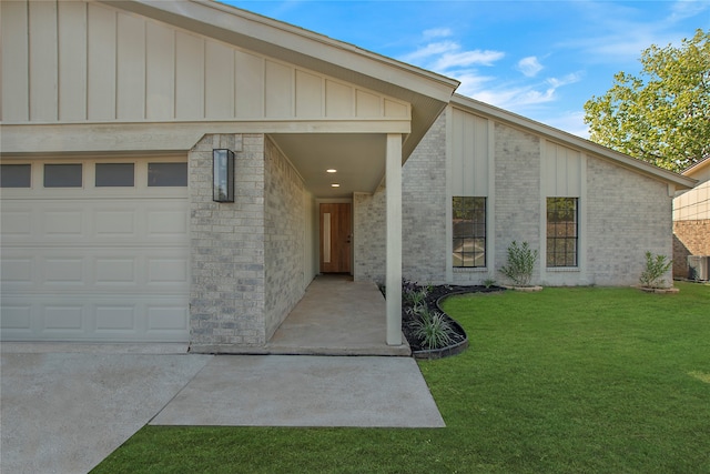 entrance to property featuring a garage and a yard