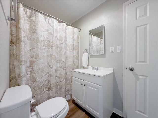 bathroom featuring wood-type flooring, vanity, and toilet