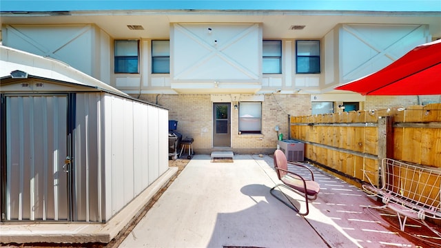 rear view of house featuring a shed and central air condition unit