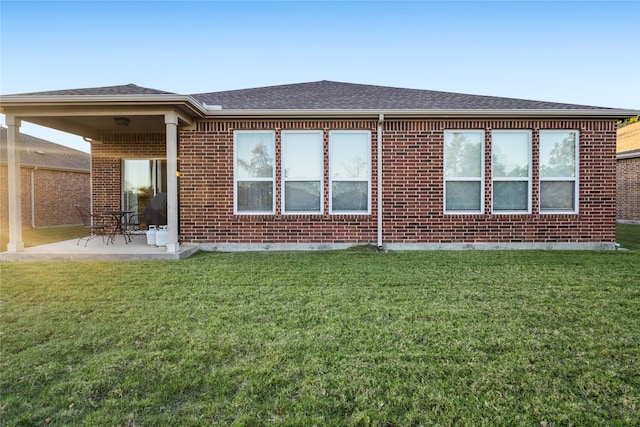 rear view of house with a lawn and a patio area