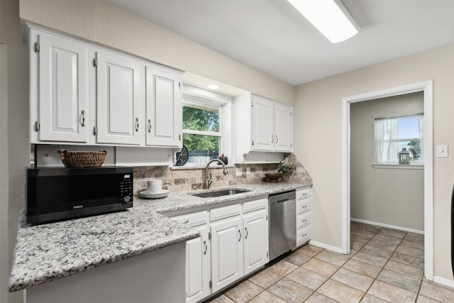 kitchen with stainless steel appliances, sink, tasteful backsplash, and white cabinetry