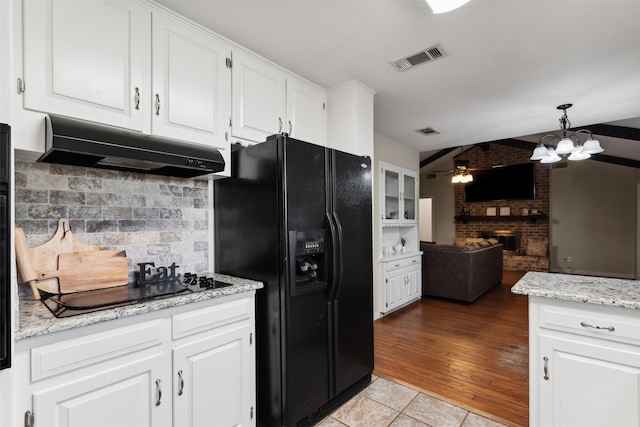 kitchen featuring a brick fireplace, light wood-type flooring, backsplash, black appliances, and white cabinetry