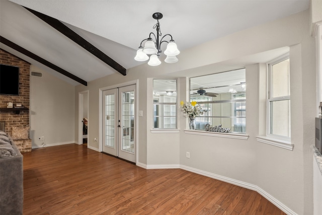 unfurnished dining area with a healthy amount of sunlight, vaulted ceiling with beams, hardwood / wood-style floors, and french doors