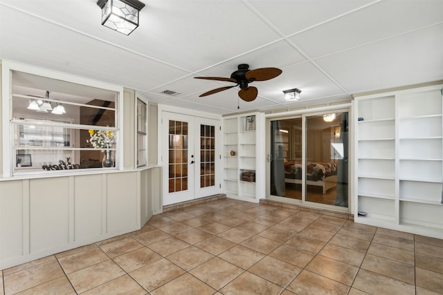 interior space with built in features, ceiling fan, french doors, and light tile patterned floors