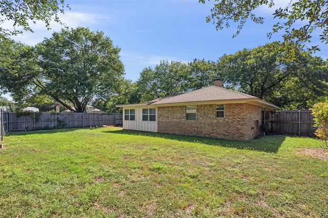 back of property featuring a yard