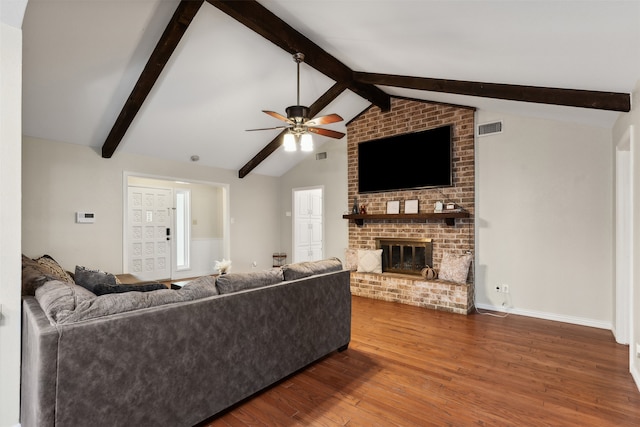 living room featuring ceiling fan, hardwood / wood-style flooring, a fireplace, and vaulted ceiling with beams