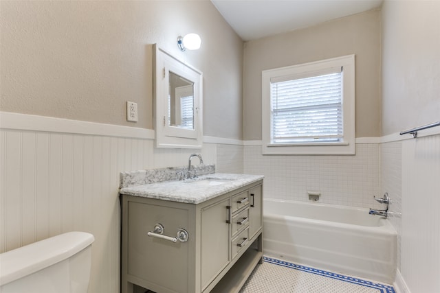 bathroom with vanity, toilet, and a tub to relax in