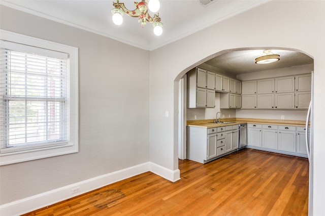 kitchen featuring butcher block countertops, sink, light hardwood / wood-style floors, and a textured ceiling