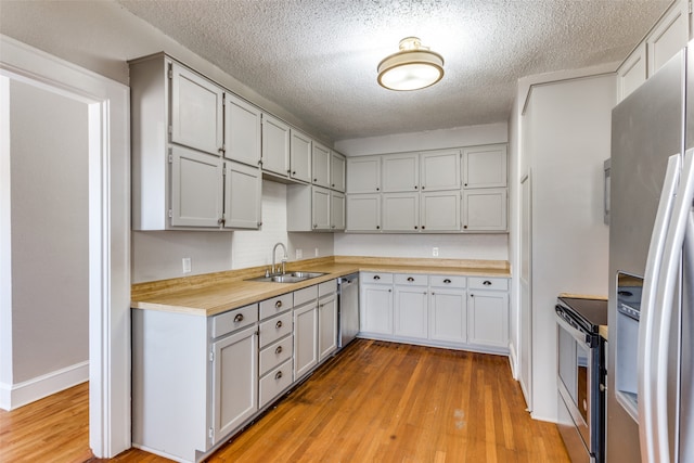 kitchen featuring butcher block countertops, sink, light wood-type flooring, and stainless steel appliances