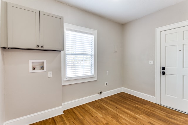 laundry room with hookup for an electric dryer, hookup for a washing machine, cabinets, and wood-type flooring