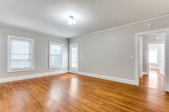 spare room with plenty of natural light, wood-type flooring, and a textured ceiling