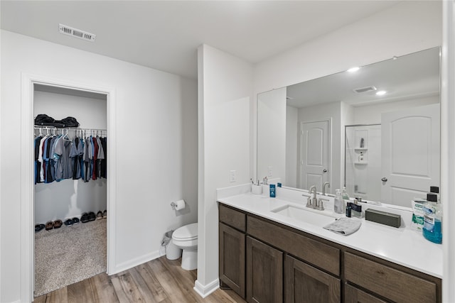 bathroom with vanity, hardwood / wood-style floors, toilet, and a shower with shower door