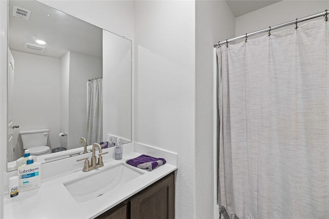 bathroom featuring a shower with shower curtain, vanity, and toilet