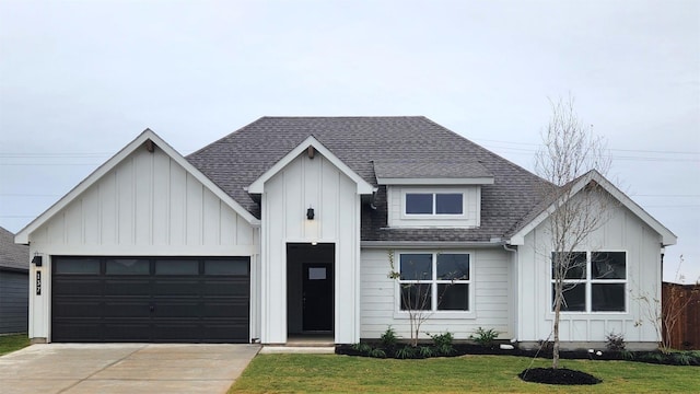 modern farmhouse featuring roof with shingles, driveway, board and batten siding, a front lawn, and a garage