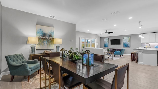 dining area featuring ceiling fan, sink, and light hardwood / wood-style flooring