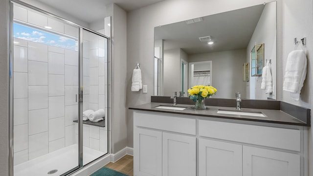 bathroom with vanity, wood-type flooring, and a shower with door