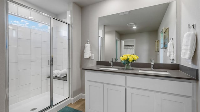 full bathroom with a shower stall, wood finished floors, a sink, and visible vents