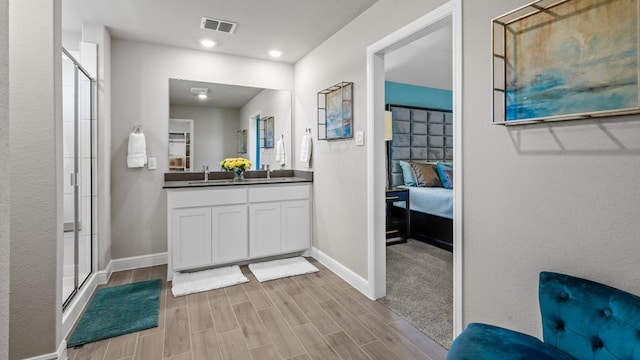 bathroom with hardwood / wood-style flooring, vanity, and walk in shower