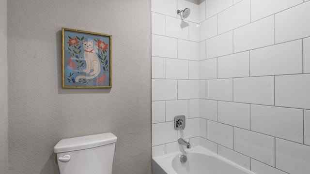 bathroom with toilet and tiled shower / bath