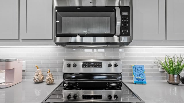 kitchen with white cabinets, appliances with stainless steel finishes, and tasteful backsplash